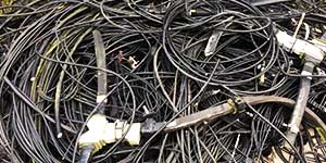 close up view of home domestic black and grey computer electrical cables cioled up together in a very large pile awaiting collection