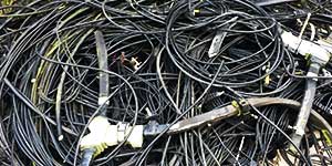 close up view of home domestic black and grey computer electrical cables cioled up together in a very large pile awaiting collection