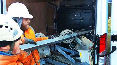 close up view of a pile of typical factory and industrial site scrap metal including machinery being loaded into a white van by two howarths clearance experts