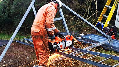 photo side close up view of a howarth site dismantling expert using mechanical grinding equipment to cut through a metal framework construction ready for clearance from the site now it is no longer required