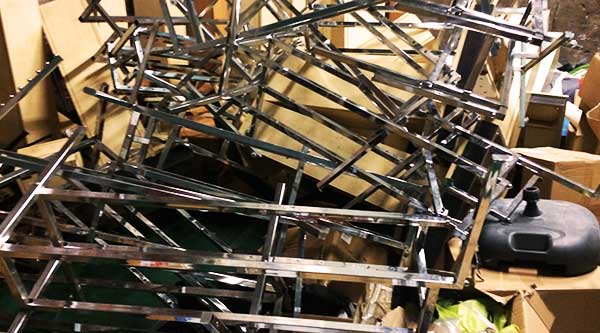 close up of a large amount of metal chromed shelving rails in a huge pile along with old metal stock including pallet racking and chrome fixtures and fittings