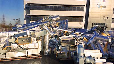 distance view of a large pile of office air conditioning piping vents ducts grills and metal box tubes being loaded onto sheffields howarth recyclings collections vehicle