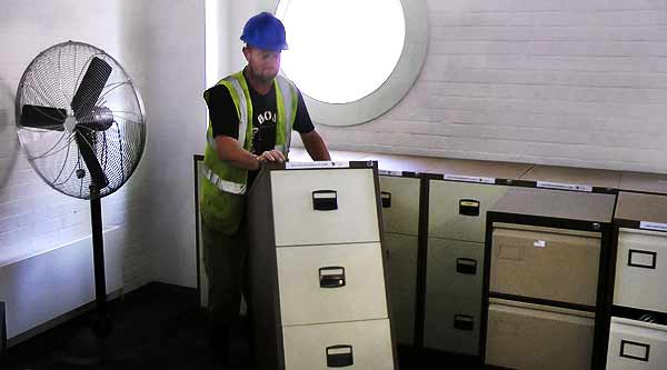 close up view of a collection of office clearance items including chairs tables computers and filing cabinets inside an office building by howarth scrap metal company sheffield scrap men