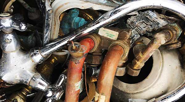 photo close up of old plumbing scrap for collection including stainless steel single sink and tap along with copper pipesand silver fittings