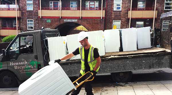 distance side view of a howarth expert complete with a fridge on a sack barrow heading towards the howarth fridge removal vehicle