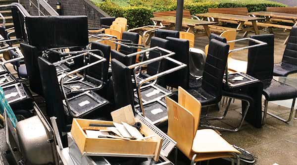 distance view phoyo of a medium sized pile of catering cafe chairs and electrical catering kitchen equipment