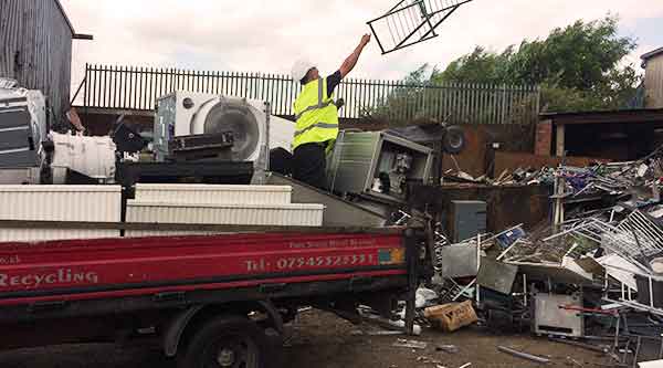 scrap metal men unloading a full load of sheffields unwanted scrap metal from their truck in their scrap company recycling premises