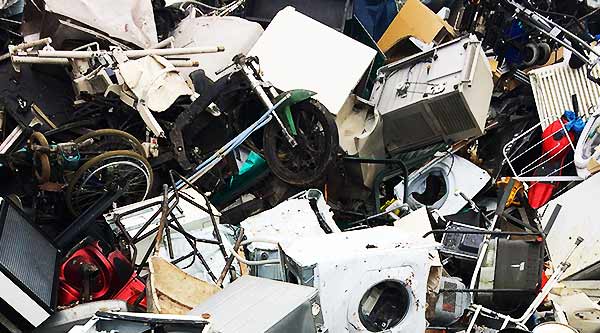 photo of a large pile of unwanted house hold scrap metal items such as fixtures and bits of useless metal and panels along with vacuums and metal windows and doors